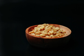 salted broad beans close-up in a wooden bowl. side view, good for recipe or commercial, isolated on black background