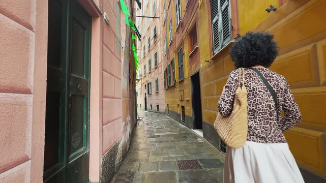 Business woman walk exploring scenic narrow street alley in historic Camogli, Italy