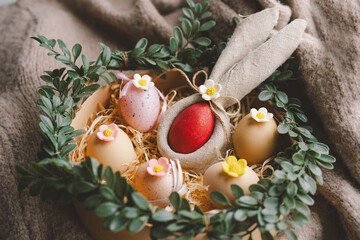 A decorative nest for Easter displays colorful eggs with floral accents, nestled in soft straw and...