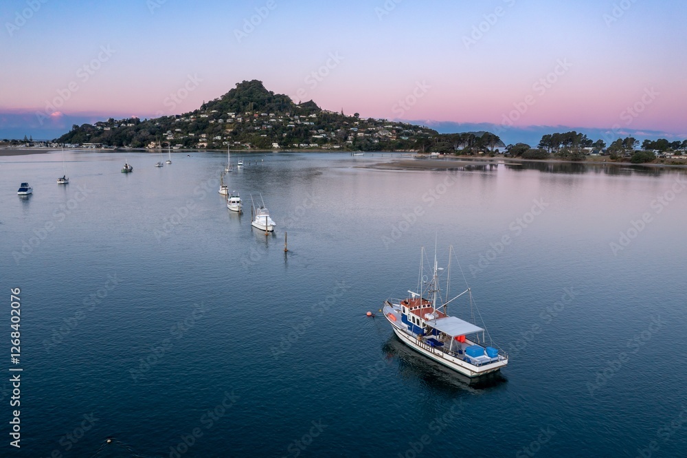 Poster Tranquil morning scene on the water. Fishing boat  navigates calm waters near coastal town. Peaceful harbor at dawn. Tairua, Coromandel Peninsula, New Zealand