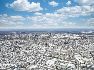 Naklejka premium Aerial drone view of New Providence, New Jersey, covered in snow. The frozen landscape highlights roads, homes, and infrastructure, showcasing the suburban town in the cold season.
