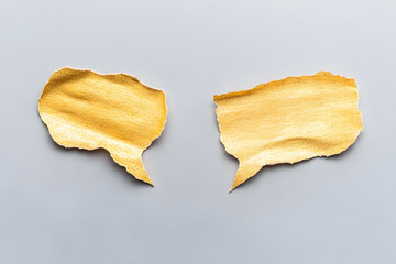 Naklejka premium Golden speech bubbles on gray background symbolize conversation and communication