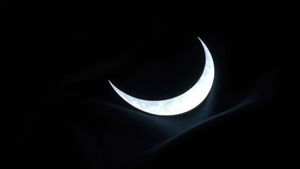 A delicate crescent moon shape casts an ethereal glow on a dark fabric, crescent, dreamy