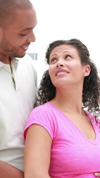 Portrait of a pregnant couple with arms around