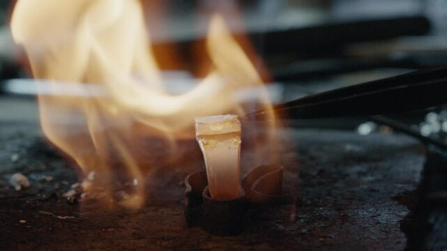 Jeweler heating gold with a torch in workshop