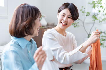洋服を持ち笑顔で話す親子