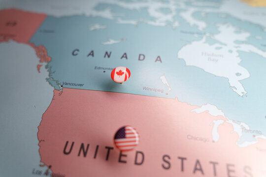 Canadian flag push pin marking Canada on a map