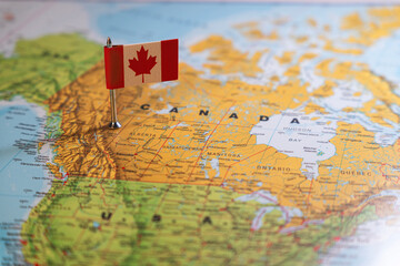 A Canadian flag pinpointed on a map of Canada, symbolizing national identity and geographical location