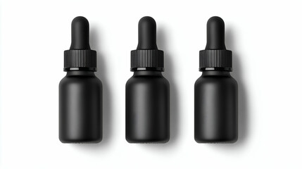 Obraz premium Three sleek black dropper bottles arranged in a row, ideal for essential oils or serums.