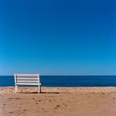 White Bench on Sandy Beach Under Blue Sky