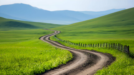 Naklejka premium Winding Dirt Road Through Lush Green Fields and Rolling Hills
