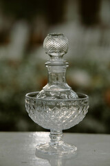Glass water jug ​​used in Thai wedding ceremony, close-up shot, blurred background, antique glass vase
