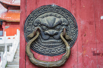 ancient asian lion doorknob handle decoration of wooden temple door	