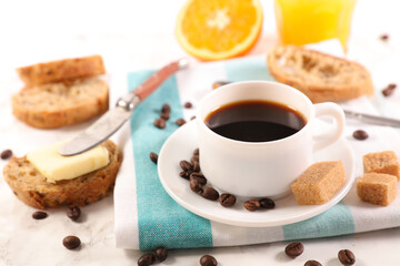 Coffee Cup with Bread, Butter, and Orange Juice on a Table