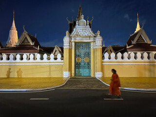 Monks passing by Royal Palace of Cambodia at night
