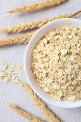 Composition with oatmeal flakes on gray background. Cooking breakfast