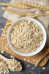 Composition with oatmeal flakes on gray background. Cooking breakfast