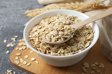 Composition with oatmeal flakes on gray background. Cooking breakfast