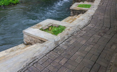 Close-Up of Small Concrete Plaster Stairs by Mountain River with Paved Path and Bathing Steps