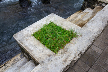 Close-Up of Small Concrete Plaster Stairs by Mountain River with Paved Path and Bathing Steps