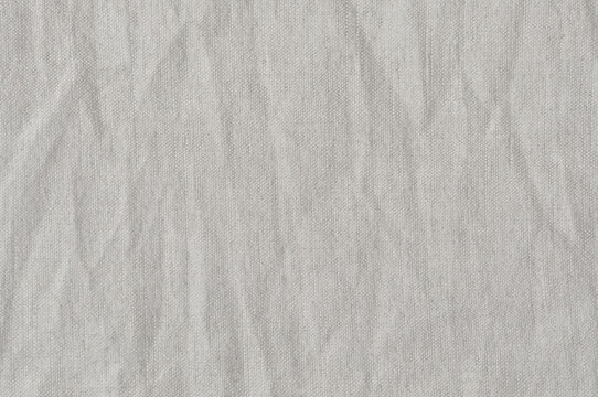 Natural bright linen cotton blend chinos trousers background, large detailed horizontal flax fibers macro closeup, rustic crumpled vintage textured burlap grey white khaki canvas fabric swatch pattern