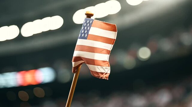 A USA flag waving at a baseball game during the seventh-inning stretch