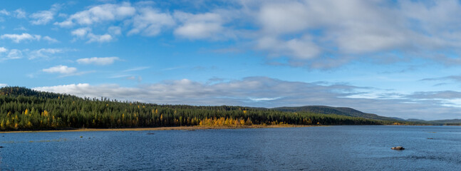 Afternoon panoramic view from Trollforsen rapids in swedish lapland against blue sky with fair weather clouds