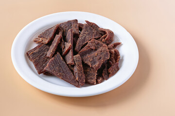 Sweet and spicy beef jerky served on a white plate