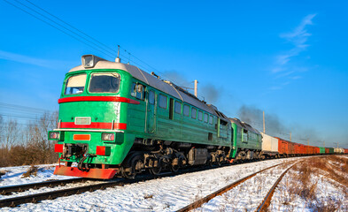 Obraz premium Diesel locomotive with a heavy freight train in winter in Kovel, Volyn Oblast of Ukraine