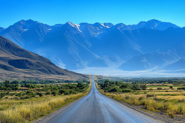 Endless Open Road Leading to Majestic Blue Mountain Range Under Clear Sky