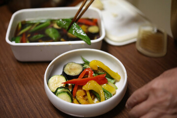 夏野菜の揚げびたしを作る女性