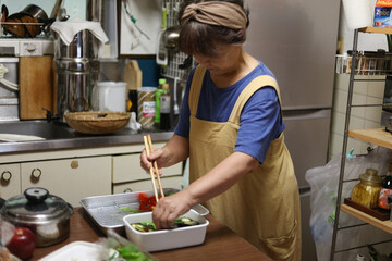 夏野菜の揚げびたしを作る女性