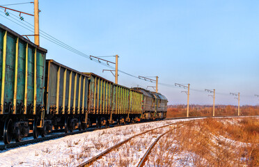 Fototapeta premium Heavy iron ore freight train for Poland in winter. Kovel, Volyn Oblast of Ukraine