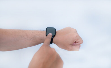 Fototapeta premium male hand wearing smart watch with blank screen on white background.Wearable technology concept.