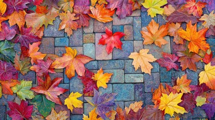 A vibrant arrangement of autumn leaves scattered on a textured stone surface.