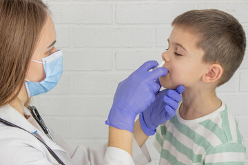 Female doctor drips drops into nose. Pediatrician's appointment, healthcare concept.