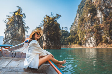 Traveler asian woman relax and travel on Thai longtail boat in Ratchaprapha Dam at Khao Sok National Park Surat Thani Thailand