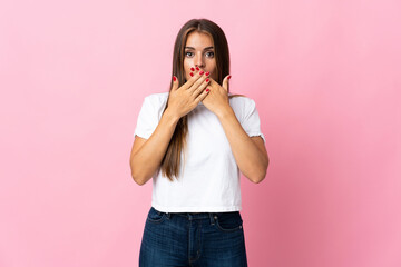 Young Uruguayan woman isolated on pink background covering mouth with hands