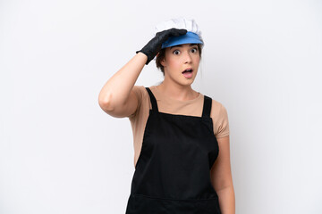 Fishmonger brazilian woman wearing an apron isolated on white background doing surprise gesture while looking to the side