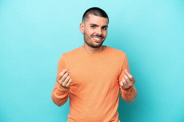 Fototapeta premium Young caucasian man isolated on blue background making money gesture
