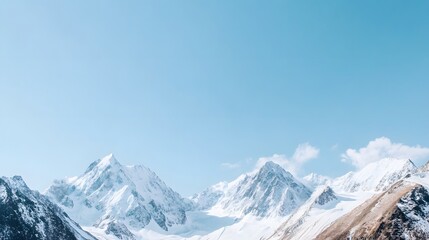 Obraz premium Majestic snow-capped mountains under a clear blue sky during midday in a serene landscape