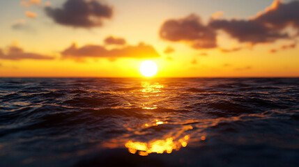 Obraz premium Golden Sunset Over Wavy Ocean Surface with Reflective Sunlight and Layered Cloudy Sky