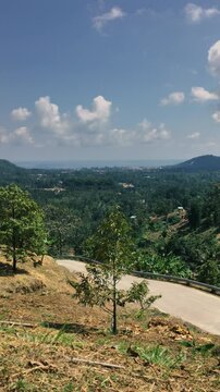 A mountain road in the tropics with car and motorcycle traffic