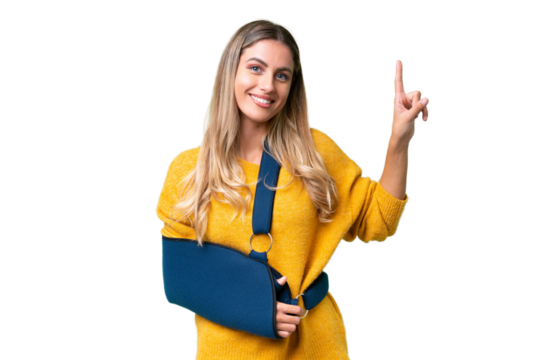 Young Uruguayan woman with broken arm and wearing a sling over isolated background pointing up a great idea