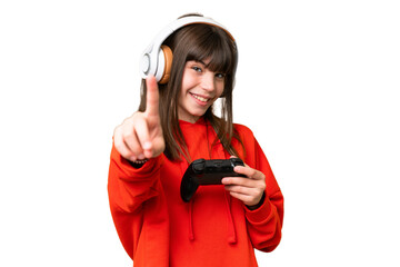 Little caucasian girl playing with a video game controller over isolated background showing and...