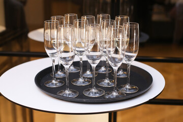 Champagne toast at a banquet background. Welcoming guests with wine. Empty glasses on a tray after the party. Elegant celebration setting. Cheers at a reception.