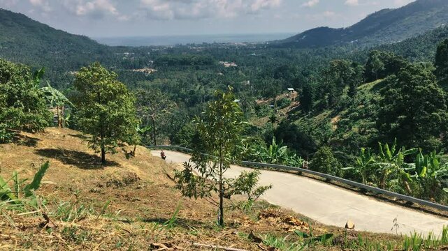Mountain road in the tropics with motorcycle traffic