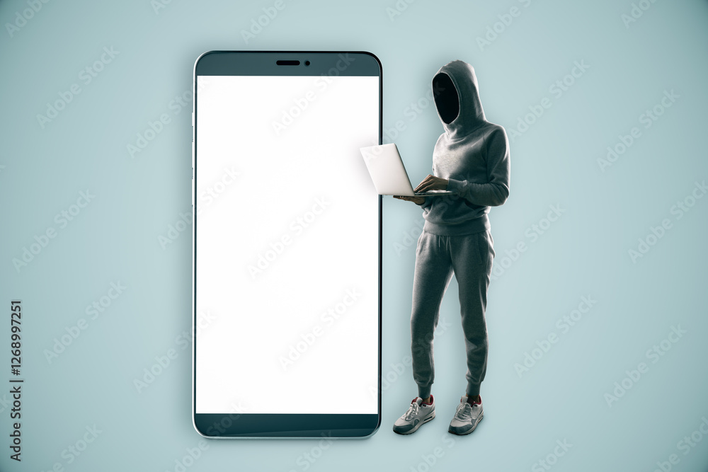 Poster Anonymous person in hoodie using laptop next to large smartphone with blank screen.