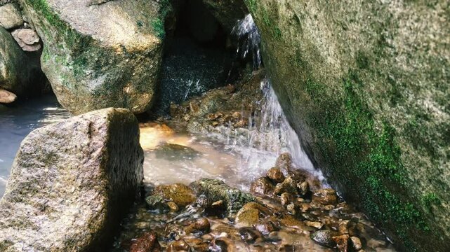The water of a mountain stream pours on the rocks with splashes