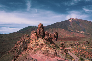 Panorama view over volcanic rock formation called La Catedral with epic mountains on the background with summit of Pico del Teide during hot summer day on Tenerife nature park, Canary, Spain